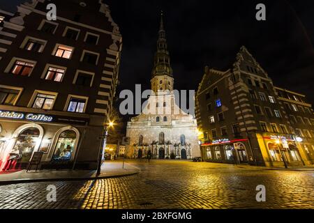 RIGA, LETTLAND - 1. JAN 2017: St. Peter Kirche und andere Gebäude in Rigas Altstadt bei Nacht. Stockfoto