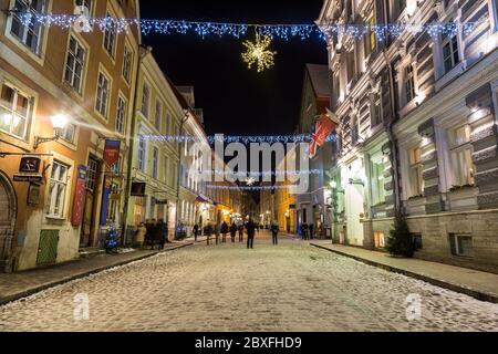 TALLINN, ESTLAND - 3. JAN 2017: Ein Blick auf die Vene Street in Tallinn während der Festmonate. Dekorationen, Gebäude und Menschen sind zu sehen. Stockfoto