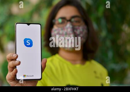 New York, USA,2020. Mädchen trägt Maske zeigen Skype-App auf Handy unter häuslicher Quarantäne für Corona-Virus (Covid-19) Krankheit Pandemie.Skype hat sich MOS Stockfoto