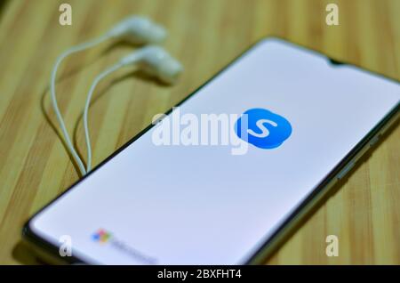 London, Großbritannien, 2020. Flache Lage des Skype App-Symbol auf dem Smartphone-Bildschirm auf dem Display und ein Paar Kopfhörer auf einem Holzbrett Hintergrund. Skype ist ein popu Stockfoto