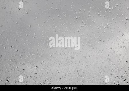 Regentropfen am Fenster - Blick aus dem Fenster nach außen, regnerisches Wetter, Textur Hintergrund Stockfoto