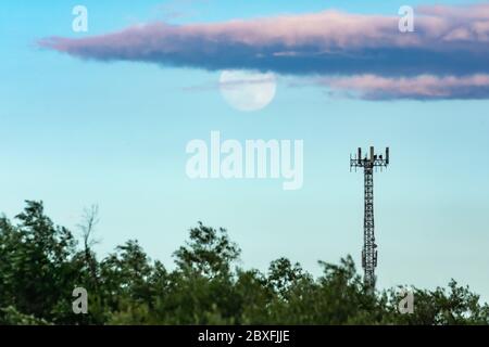 Turm mit Handy-Antennen oder Repeater mit Vollmond im Hintergrund Stockfoto