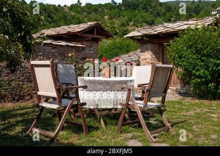 Traditionelle Gartenmöbel Tisch und Holzstühle im Dorf Kovachevitsa auf dem Rhodopen-Berg, Bulgarien, Osteuropa, Balkan Stockfoto