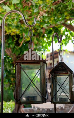 Alte rostige Laternen Lampen auf Holz-Tisch als Gartendekoration im traditionellen Haushinterhof in Bulgarien auf der Balkanhalbinsel Stockfoto