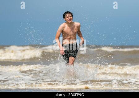 Southport, Merseyside, 7. Juni 2020. Ein schöner Tag am Strand, als Elliot Swinden und seine Freunde, alle qualifizierten Rettungsschwimmer, sich austoben, da sie viel Spaß beim Spielen im Meer vor Southport Beach in Merseyside haben. Quelle: Cernan Elias/Alamy Live News Stockfoto