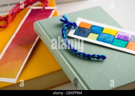 Bunte Lesezeichen auf einem geschlossenen gelben und grünen Buch. Bildung. Lesen. Stockfoto