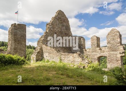 Die Ruinen einer mittelalterlichen Burg, die an einem leicht bewölkten Sommertag von der Sonne beleuchtet wird. Markierungen oben. Stockfoto