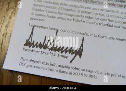 Unterschrift auf Spanisch am unteren Ende des Briefes von Präsident Donald J. Trump, der den CARES Act und seine Stimulus-Zahlung erklärt. Stockfoto