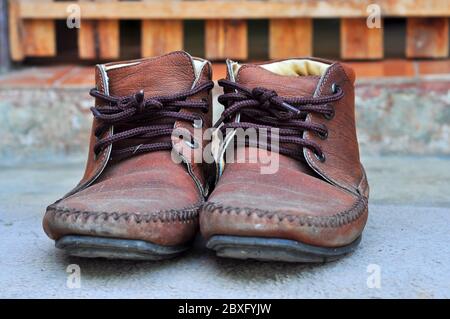 Braune Lederschuhe mit Schnürsenkeln wurden zur Seite gelegt. Stockfoto