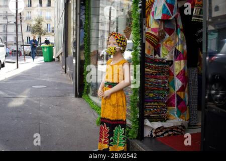 Kinderladen Schaufensterpuppe mit Gesichtsmaske, African (Senegalese) Stoffladen - Rue Myrha, 75018 Paris Frankreich Stockfoto