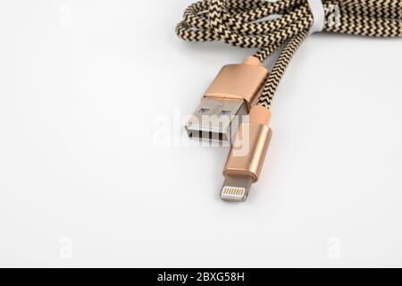 USB-zu-Lightning-Kabel auf weißem Hintergrund. Telefonzubehör, Ladegerät und Datenübertragung Stockfoto