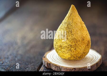 Gebratenes Hühnerbein auf rustikalem Holzhintergrund, typisch brasilianisches Essen. Stockfoto