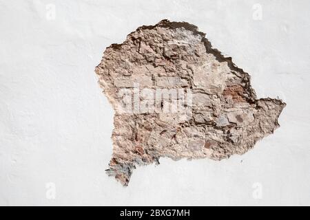 Durch das Loch in der Wand ist es die Ziegel sichtbar. Reparatur, Restaurierung, Bau und historische Beweise. Ton und Dolomit Stockfoto