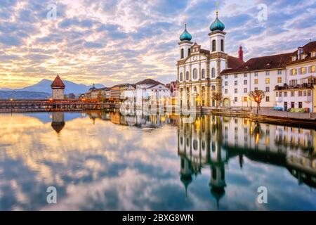 Luzerner Altstadt, Schweiz, Blick auf die Reuss, Kapellbrücke und Jesuitenkirche bei dramatischem Sonnenaufgang Stockfoto