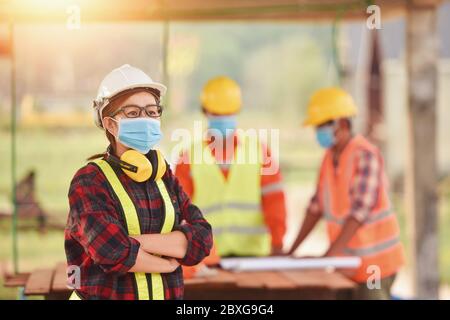 Drei Ingenieure auf einer Baustelle mit Gesichtsmasken, Thailand Stockfoto