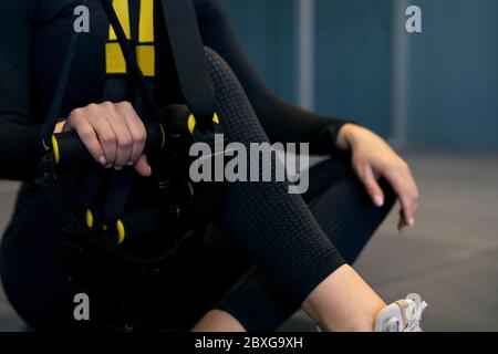 Frau sitzt auf dem Boden mit Trainingsbändern Stockfoto