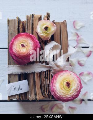 Stapel alter Bücher mit Blumen auf einem Holztisch Stockfoto