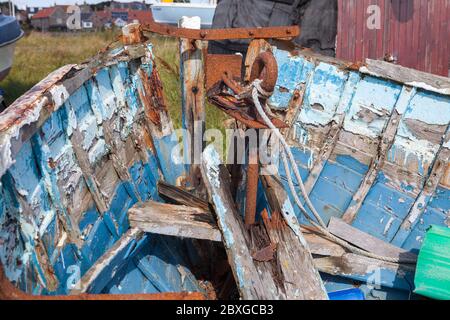 Der Rumpf eines verlassenen Fischerboots, das am Ufer von Lindisfarne, Northumberland, verrottet Stockfoto