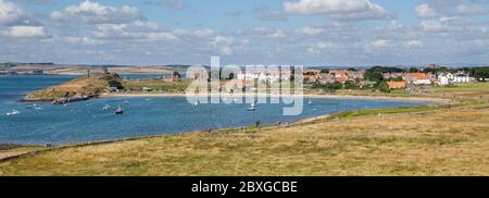 Blick über den Hafen und die Bucht in Richtung der Ruinen und des Dorfes auf Lindisfarne, Northumberland Stockfoto