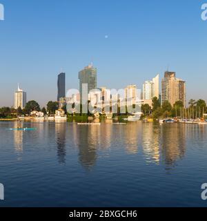 WIEN, ÖSTERREICH - 1. SEPTEMBER 2015: Gebäude in der Nähe des Danau Parks in Wien am Morgen. Man kann Leute im Wasser rudern sehen. Stockfoto