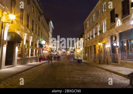 MONTREAL, KANADA - 17. MAI 2015: Blick auf die Rue Saint Paul Est in der Altstadt von Montreal bei Nacht, wo Gebäude und die Unschärfe der Menschen zu sehen sind Stockfoto