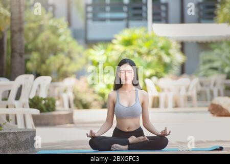 Schöne Frau in Lotushaltung meditierend, Thailand Stockfoto