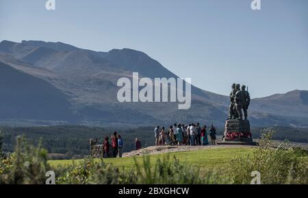 Touristen besuchen das Commando Memorial an der Spean Bridge mit Bronzestatuen, die über das Trainingsgelände des Kommandos in der Ben Nevis Bergkette blicken Stockfoto