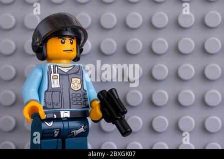 Tambow, Russland - 04. Juni 2020 Porträt des Lego-Polizisten Minifigur mit Pistole auf grauem Grundplattenhintergrund. Studioaufnahme. Stockfoto