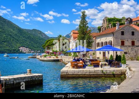 Perast, Montenegro - 18. Juli 2016: Touristen sitzen in einem Café am Wasser an einem schönen sonnigen Tag in Perast. Perast ist ein beliebtes Touristenziel i Stockfoto