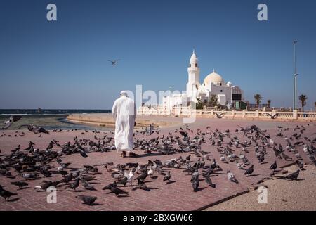 Jeddah / Saudi Arabien - 20. Januar 2020: Muslimische Gläubige füttern Tauben in der Nähe der wunderschönen Moschee am Meer Stockfoto