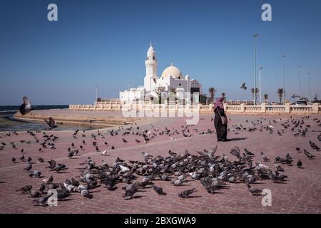 Jeddah / Saudi Arabien - 20. Januar 2020: Muslimische Gläubige füttern Tauben in der Nähe der wunderschönen Moschee am Meer Stockfoto