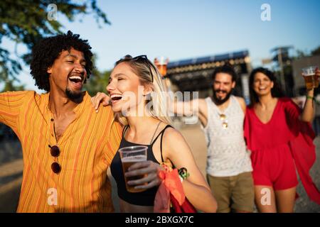 Eine Gruppe von Freunden, die Spaß haben, unterwegs sind und zusammen im Freien lächeln Stockfoto