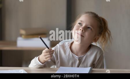 Verträumte kleine Mädchen in Gedanken verloren abgelenkt vom Studium Stockfoto