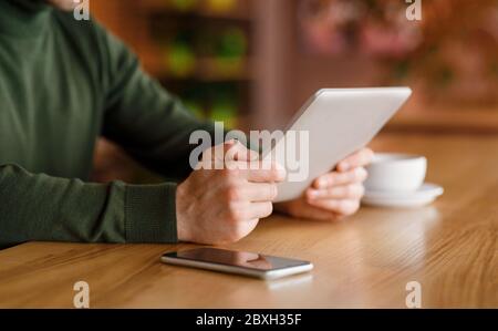 Mann hält digitales Tablet, Kaffeepause im Café Stockfoto