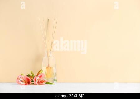 Reed Diffuser und Blumen auf dem Tisch Stockfoto