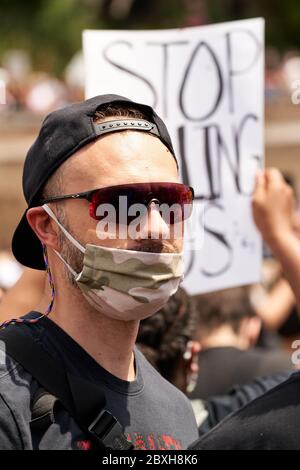 Schwarze Leben sind wichtig, Protest für George Floyd gegen Rassismus. Junger Mann mit einer Tarnmaske im Camouflage-Stil, einer militärisch-ähnlichen Sonnenbrille und einer Baseball-Kappe Stockfoto