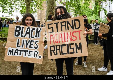 Zwei junge Frauen mit Plakaten "Black Lives Matter", "Stand gegen Rassismus" bei einem Protest zur Unterstützung von "Black Lives Matter" in London, Großbritannien. Stockfoto