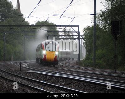LNER Klasse 800 Azuma passiert Offord Cluny im Regen auf der East Coast Main Line, Cambridgeshire UK Stockfoto