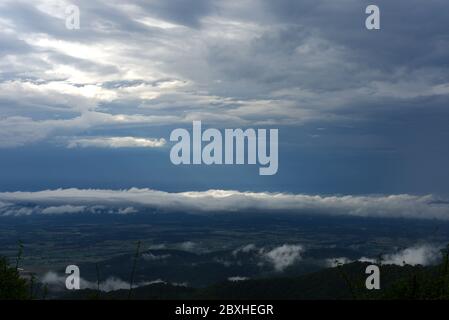 Die Sonne bricht durch einen dunklen, wolkigen und stürmischen Himmel und offenbart Licht am Himmel. Stockfoto