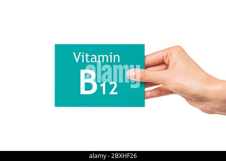 Weibliche Hand zeigt eine Karte mit der Aufschrift Vitamin B12. Vitamin B12. Stockfoto