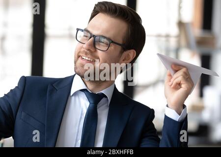 Lächelnder Geschäftsmann lachen Papier Flugzeug im Büro Stockfoto