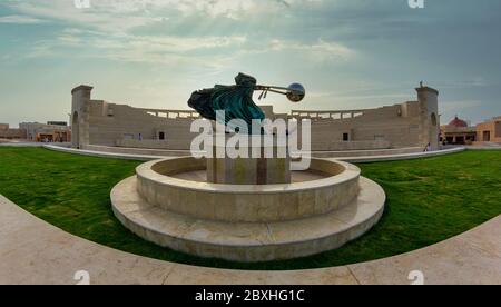 Das Amphitheater in Katara Cultural Village, Doha Katar Panoramablick bei Tageslicht mit Force of Nature 2 Statue im Vordergrund und Wolken am Himmel Stockfoto