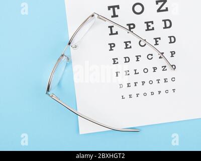 Brille und Optikerkarte auf blauem Hintergrund. Stockfoto