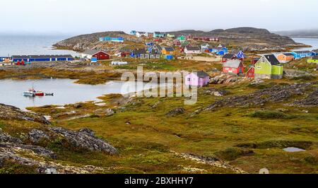 Bunt bemalte Häuser von Itilleq klettern auf niedrige Hügel rund um den Stadthafen. Es handelt sich um ein Dorf mit 85 Inuit-Einwohnern an der Südwestküste Grönlands. Stockfoto