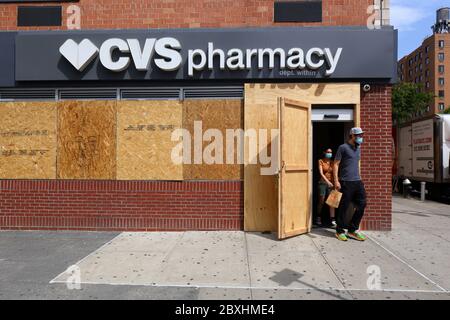 New York, New York, 4. Juni 2020. Käufer, die eine CVS-Apotheke verlassen, mit verschlossenen Fenstern, nachdem kürzlich eine große Anzahl von organisierten Einbrüchen/Plünderungen in anderen Teilen der Stadt stattgefunden hat. Das Geschäft schließt sich anderen Unternehmen in der Stadt an, die Angst vor Vandalismus haben, indem es als Vorsichtsmaßnahme ihre Fenster und Türen aufhebt und während der covid-19-Pandemie für Geschäfte geöffnet bleibt. Die vielen verschlossenen Ladenfronten in der Stadt senden eine Botschaft der Hoffnungslosigkeit und Verzweiflung an viele, die es nicht gewohnt sind, so viele verschlossene Ladenfronten in einer normalerweise lebhaften und geschäftigen Stadt zu sehen. Juni 2020 Stockfoto