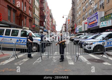 New York, NY, 5. Juni 2020. Eine Wohnstraße in Chinatown, die das 5. Bezirkhaus der NYPD beherbergt, ist verbarrikadiert und wird von der Polizei bewacht. Nach mehreren Zwischenfällen von Polizeistationen im ganzen Land, die aufgrund von Unruhen angegriffen wurden, hat die New Yorker Polizei ihre Gebäude isoliert, indem sie alle verbarrikadiert und den Zugang zu ihnen verhindert hat, es sei denn, sie können nachweisen, dass sie auf der Straße leben oder arbeiten. Für einige kann es bedeuten, Härte und große Unannehmlichkeiten. Die Rechtmäßigkeit der Straßenschließung ist fraglich. Juni 2020 Stockfoto