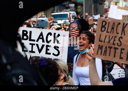 Juni 2020. Umgeben von "Black Lives Matter"-Zeichen schreit eine Frau zur Unterstützung eines solidaritätsmarsches von Black Lives Matter durch Manhattan, der in einer Reihe von amerikanischen Polizeimorden Gerechtigkeit fordert: George Floyd, Breonna Taylor und zahllose andere. Tausende von Menschen nahmen an dem protestmarsch von Brooklyn aus Teil, der Manhattan durchquere, weit hinter einer Ausgangssperre, die Anfang der Woche herausgegeben wurde, um organisierte Einbrüche und Plünderungen einzudämmen. Juni 2020 Stockfoto