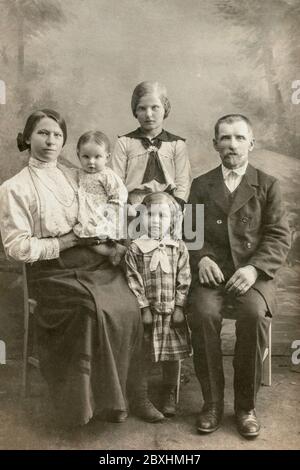 Deutschland - UM 1910: Ein Familienstudio, das einen reifen Mann mit einer jungen Frau und drei Kindern im Studio fotografiert. Foto der Vintage Carte de Viste Edwardian Ära Stockfoto