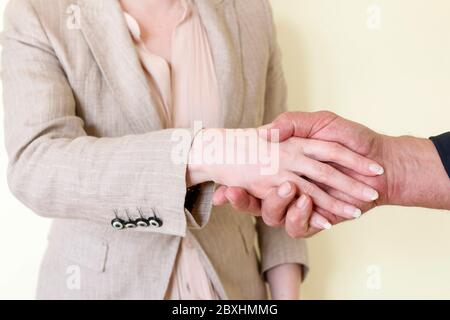 Die Frau und der Mann haben eine Geschäftsvereinbarung getroffen. Sie schütteln die Hände. Stockfoto