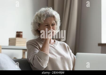 Traurige ältere Frau fühlen sich gestresst Lesen schlechte Nachrichten auf dem Laptop Stockfoto